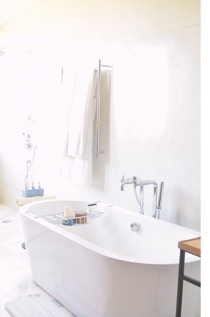 a white bathroom with the bath as the center image ready for you to take some self-care time