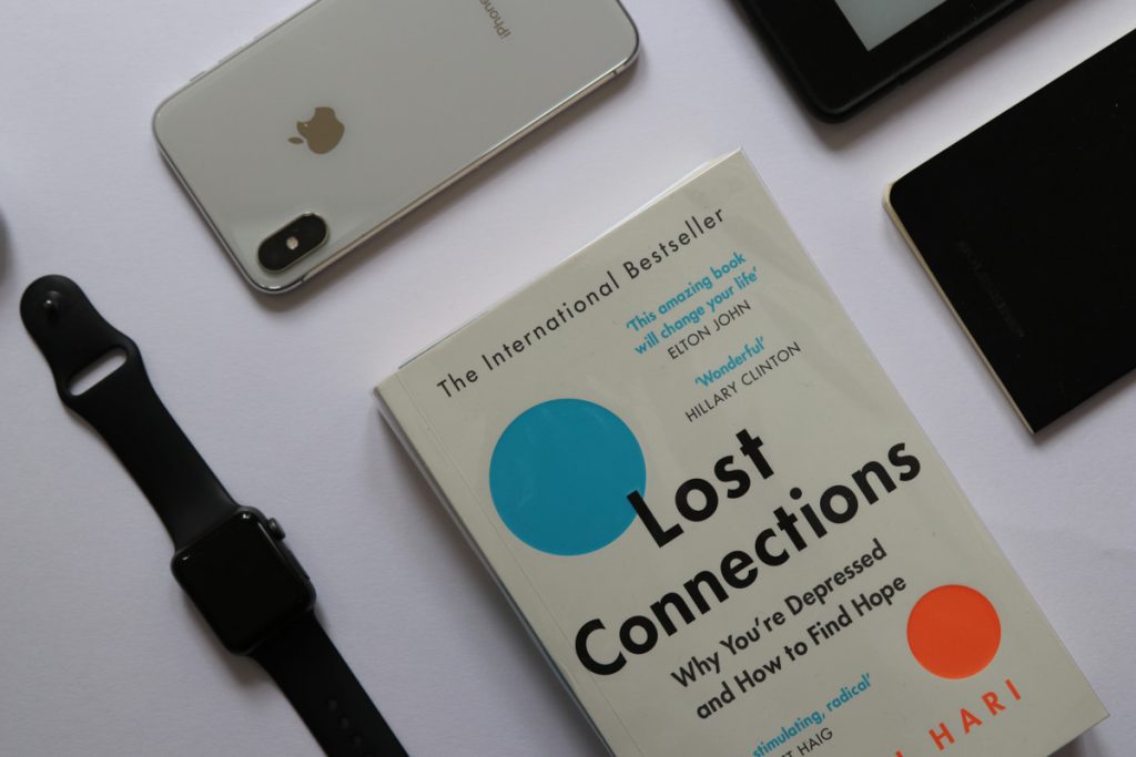 Disconnect and unplug from daily living. Phone turnedoff. Technology put away and the reading book 'lost connections' is at the centre of the image