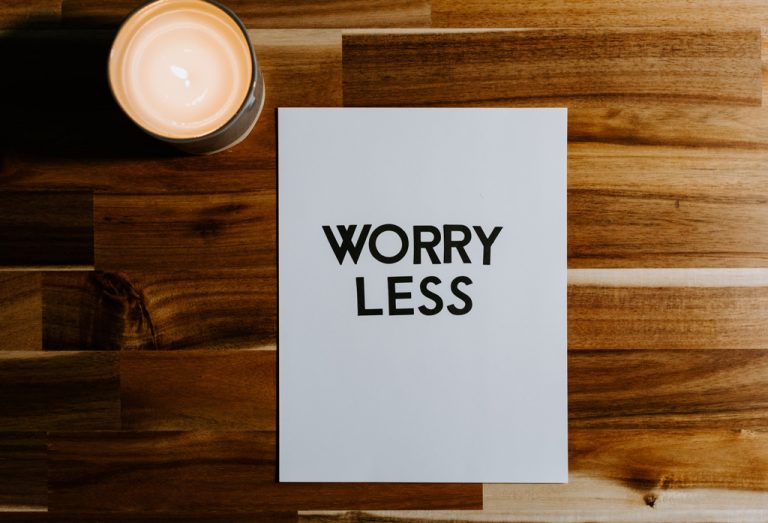 sign saying 'worry less' with a cup of coffee in the left hand corner