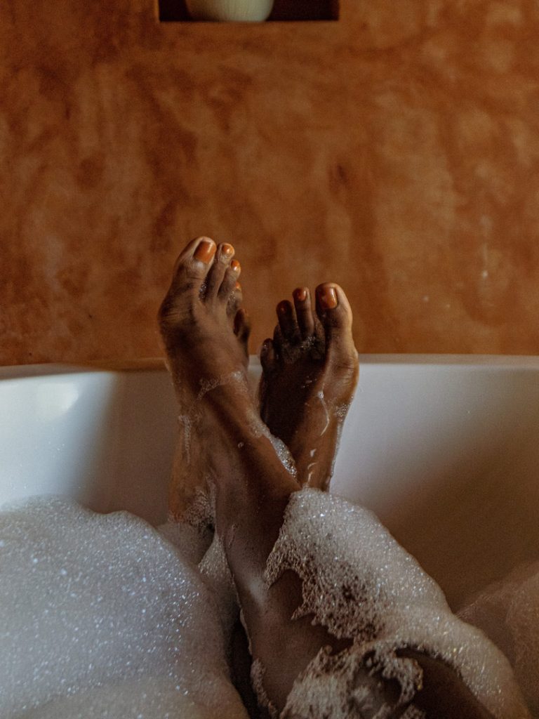 persons feet in a bubble bath