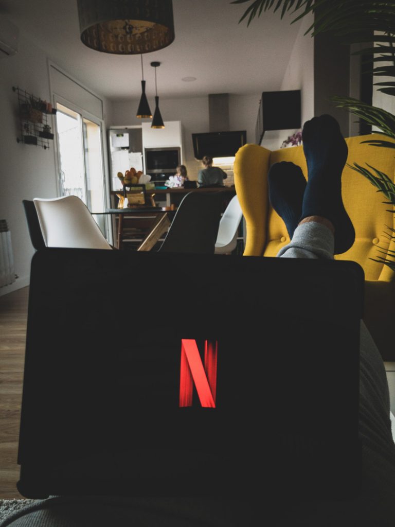 person relaxed watching netflix on laptop